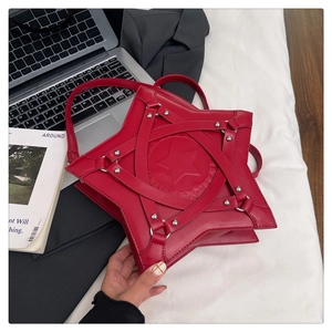 Detail view of red star-shaped leather bag with silver studs and circular embossed logo