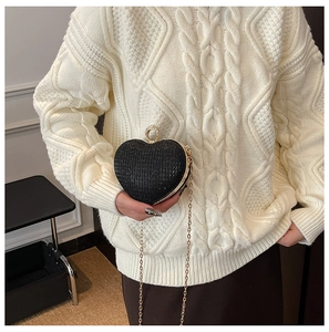 Détail du sac pailleté noir en forme de cœur avec boucle strass dorée et chaîne