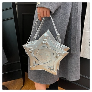 Close-up of silver star-shaped shoulder bag featuring embossed star detail and metallic strap