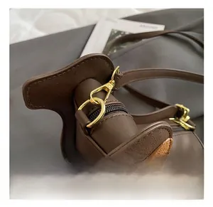 Detailed close-up of the golden metal hook and leather stitching on a dachshund bag