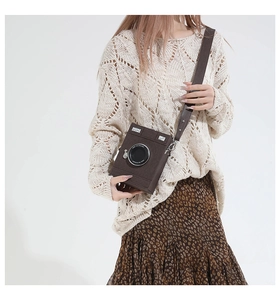 Retro camera-shaped crossbody bag in brown faux leather shown on a model