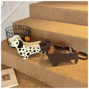 Detail showing dachshund-shaped crossbody bags in polka dot and brown leather finishes