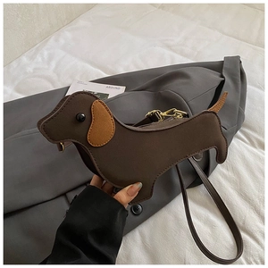 Detailed view of a creative brown dachshund dog-shaped shoulder bag with golden hardware