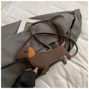 Detail of the brown dachshund dog crossbody bag with long ears and leather texture