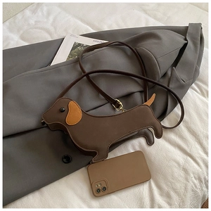 Macro detail of dachshund shaped bag showing interior capacity with a smartphone
