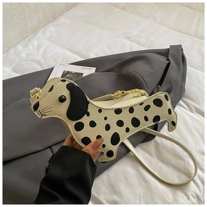 Close-up of spotted dog-shaped crossbody bag with black ears and gold hardware details