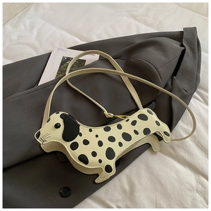 Detail of spotted dalmation-style dog shaped crossbody bag with golden hardware accents