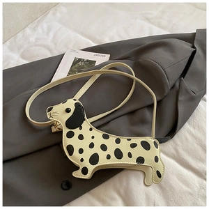 Detail of dachshund-shaped crossbody bag in creamy white with black polka dots