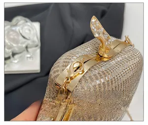 Close-up of champagne gold apple evening bag with leaf metal clasp and rhinestones