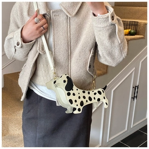 Chic dalmatian dog shaped crossbody bag styled on model in a cozy interior setting