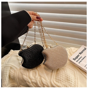 Detail of apple-shaped evening bags with sparkling texture and crystal leaf clasp
