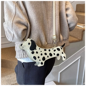 Close-up of creative dachshund crossbody bag with dalmatian spots and gold hardware