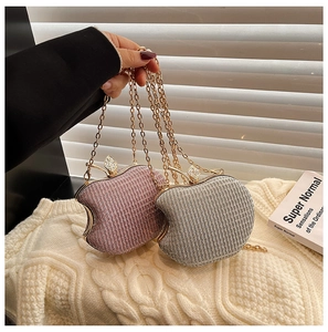 Detail of apple-shaped acrylic evening bags with glitter finish and rhinestone leaf clasp