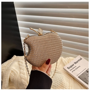 Detail of apple-shaped evening clutch with gold glitter finish and crystal leaf clasp
