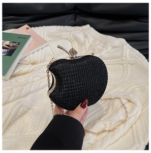 Detailed macro of apple-shaped evening bag with sparkling black finish and diamond leaf clasp