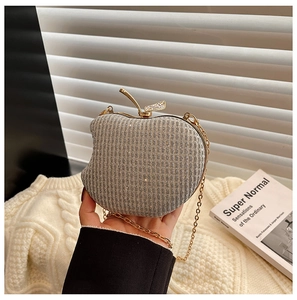 Macro shot of silver glitter apple evening bag with gold leaf clasp and metal chain