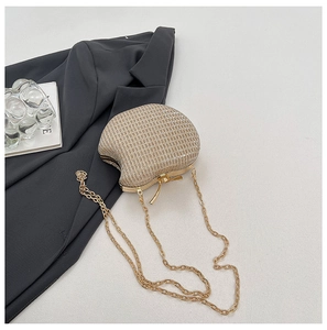 Detail shot of the golden apple-shaped evening clutch with sparkling sequins and chain