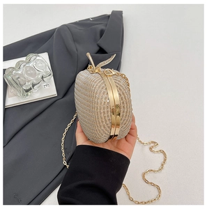 Close-up of apple-shaped evening bag featuring sparkling rhinestones and gold leaf clasp