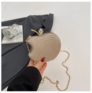 Detailed macro view of the gold apple-shaped evening clutch bag with glitter texture