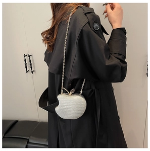 Detail showing apple shaped evening bag with silver rhinestones and gold chain strap