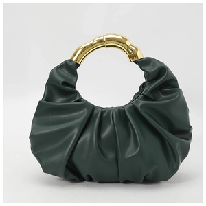 Detail of dark green ruched cloud bag featuring elegant gold metal circular handle