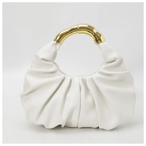 Detail of white pleated cloud bag with unique gold metallic handle texture and finish