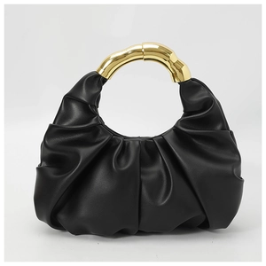 Detailed view of black pleated cloud bag with organic shaped gold metal handle