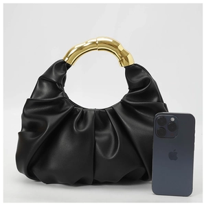 Detail of black pleated cloud bag with golden metal handle and size comparison with phone
