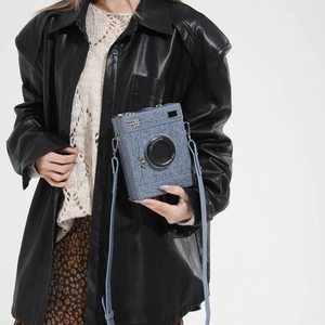 Retro camera-shaped crossbody bag in blue denim texture with adjustable shoulder strap