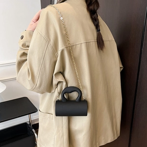 Mini sac cylindrique en acrylique noir mat avec une élégante bandoulière dorée