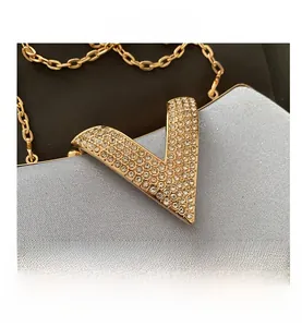 Macro detail of sparkly light blue evening bag featuring gold V-shaped diamond buckle