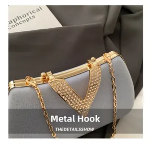 Close-up of sparkling rhinestone-inlaid V-shaped gold buckle on a light blue satin evening bag