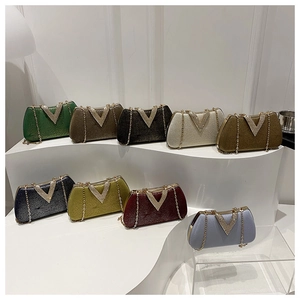 Macro view of multi-color evening bags with V-shaped rhinestone buckles and gold chains