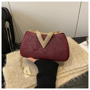 Detail of burgundy dinner clutch with sparkling fabric and rhinestone gold V-buckle