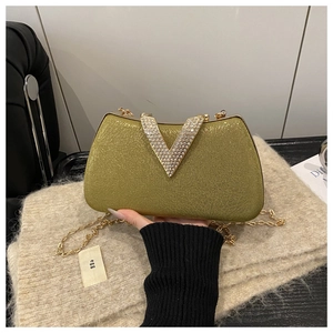 Detail of olive green sparkly evening clutch with rhinestone buckle and gold chain strap