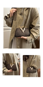 Detail of elegant black rhinestone V-clasp evening bag with gold chain strap