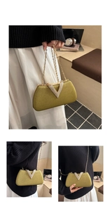 Detailed view of the gold evening bag with V-shaped rhinestone buckle and metal chain strap