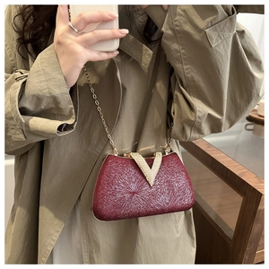 Mirror selfie showing the scale of the burgundy evening clutch with gold V-clasp