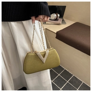 Detail of luxury gold shimmer evening bag with V-shaped rhinestone clasp and chain strap