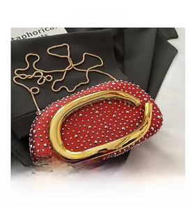 Close-up of red glitter evening bag featuring a gold C-handle and sparkling rhinestones