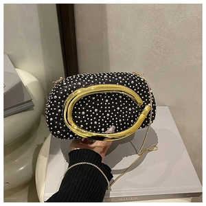 Detail der schwarzen Abendtasche mit Strasssteinen und goldenem runden Metallgriff