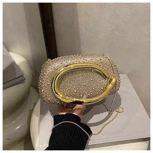 Detailansicht der goldenen Abendtasche mit funkelnden Strasssteinen und Kettenriemen