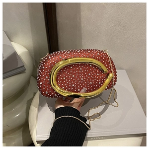 Detail einer roten Glitzer-Abendtasche mit funkelnden Kristallen und großem Goldgriff