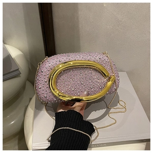 Makro-Detail der rosa Abendclutch mit silbernen Strasssteinen und goldener Ring-Griff