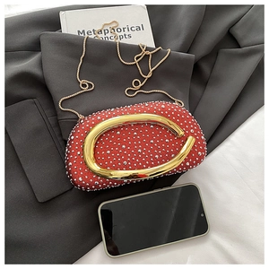 Detail der roten Abendtasche mit silbernen Strasssteinen und goldener Ring-Griff