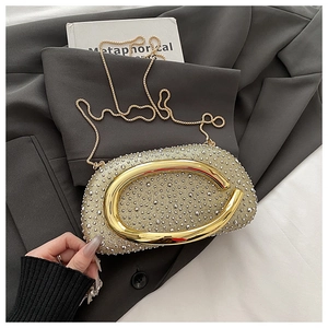 Detail der champagnergoldenen Abendtasche mit Strasssteinen und Metallring-Verschluss
