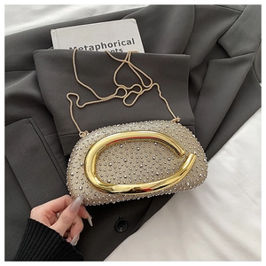Nahaufnahme der champagnergoldenen Abendclutch mit Strasssteinen und großem Metallgriff
