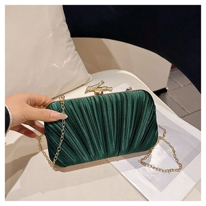 Détail d'une pochette de soirée plissée vert foncé avec fermoir en métal doré bambou