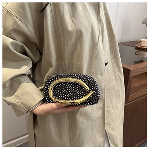 Detail of elegant black velvet clutch with sparkling silver rhinestones and gold clasp