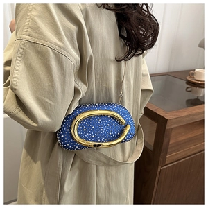 Close-up of sparkling blue rhinestone evening bag with iconic gold hardware logo